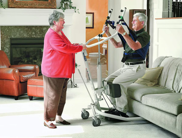 woman assisting man using a sit-to-stand lift